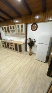 a kitchen with wooden floors and a white refrigerator at Casa de lemn in Corbu