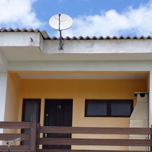 a house with a satellite dish on the roof at Morada do Sol in Ilha Comprida