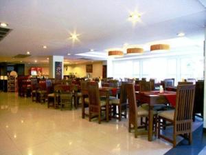 un comedor con mesas y sillas en un restaurante en Tanawit Hotel & Spa, en Hua Hin