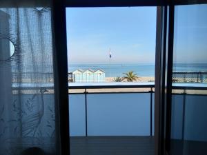 a room with a view of the beach from a window at TERRAZZA SUL MARE in Marotta