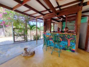 a man sitting at a bar in a house with a dog at Hostal El Bohío in Palomino