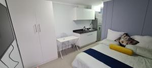 una piccola camera con letto e una piccola cucina di Modern apartments at CZ KUBS a East London