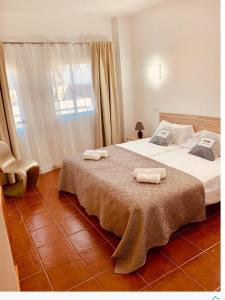 San Nicolás的住宿－Apartamento La real 3，一间卧室配有一张床,上面有两条毛巾