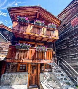 una casa in legno con piante in vaso sul balcone di Zermatterchalet a Zermatt