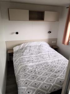 ein Schlafzimmer mit einem Bett mit einer weißen Bettdecke in der Unterkunft aventura 6 personnes in Litteau