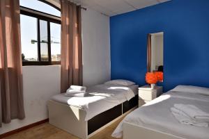 - 2 lits dans une chambre avec un mur bleu dans l'établissement Large St Julians Central 2, à San Ġiljan