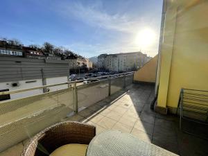 balcón con bancos y vistas a la ciudad en Apartment 122 Čertovka, en Karlovy Vary
