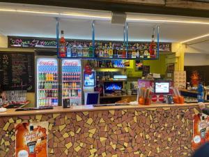 a bar in a restaurant with drinks on the shelves at Juniorcamp Nová Živohošť in Křečovice