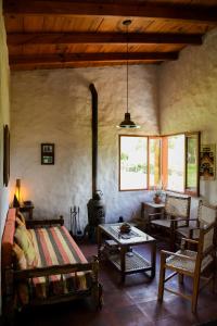 Casa en Tafí del Valle في تافي ديل فالي: غرفة معيشة مع سرير وموقد خشب