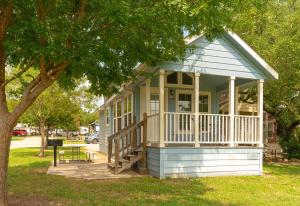a small house with a porch and a tree at Sun Outdoors Lake Travis in Hudson Bend