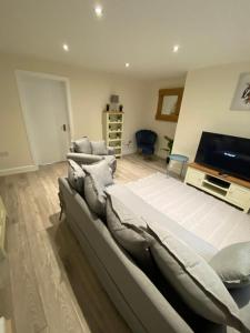 a bedroom with a large bed and a flat screen tv at Prince Cottage in West Auckland