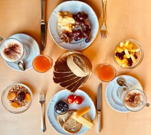 a table topped with plates of food and desserts at Hotel Capricorn in Zermatt