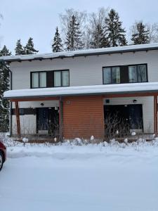 a house with snow on the ground in front of it at Дом у спа-центра и озера in Imatra