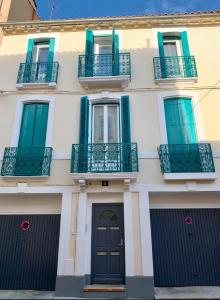 un edificio con balcones y una puerta negra en Appartement Les Halles , Climatisation, Terrasse, Garage, en Narbona