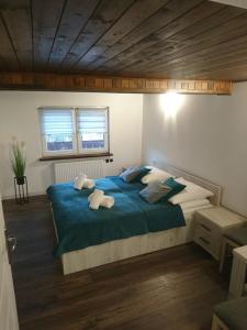 een slaapkamer met een groot bed met blauwe lakens en kussens bij Apartament ELBRUS CZYRNA Szczyrk in Szczyrk