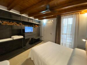 1 dormitorio con 1 cama y TV en Un moment, casa rural de 4 estrellas, en Les Coves de Vinroma