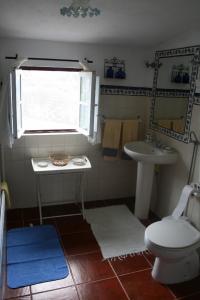 a bathroom with a sink and a toilet and a window at Monte da Linda, 5 mins from Melides beach in Melides