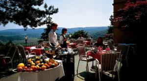 a group of people sitting at tables with fruit on them at Burghotel Volmarstein in Wetter