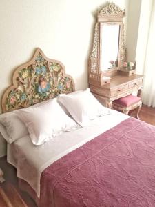 1 dormitorio con cama, espejo y mesa en Apartamento Tellería con parking gratis, en Barakaldo