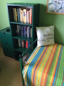 a bed with a pillow next to a book shelf at Emozione Marina - appartamento fronte mare in Marcelli