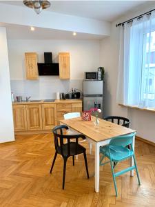 a kitchen with a wooden table and chairs and a table and a kitchen at APARTAMENTY KRUPÓWKI 35 (Maria Mąka) in Zakopane