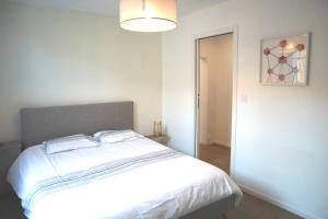 - une chambre avec un grand lit blanc et une lumière dans l'établissement MIRA BELLA - Centre ville avec jardin, à Saumur