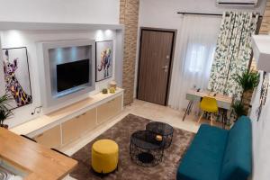 sala de estar con TV, mesa y sillas en Jolie maison Volos, en Volos