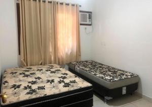 zwei Einzelbetten in einem Zimmer mit Fenster in der Unterkunft Casa Maresias Canto do mar - 50m da praia in Maresias + 40 Fotos