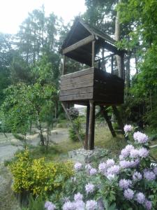 a bird feeder in a garden with flowers at chata FRIDAY in Ktová