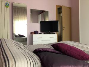 Dormitorio con cama y tocador con TV en Appartamento laurentum, en Torvaianica