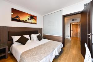 מיטה או מיטות בחדר ב-קלאב הוטל טבריה - מלון סוויטות