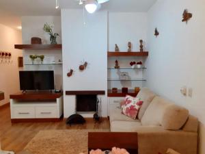 ein Wohnzimmer mit Couch und Flachbildfernseher in der Unterkunft Resort com Natureza no Centro in Gramado