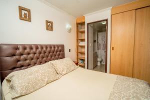 a bedroom with a bed with a brown leather headboard at Departamentos Alpro Cavancha Vista a la Playa in Iquique