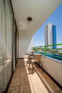 d'un balcon avec une table et une vue sur un bâtiment. dans l'établissement Departamentos Alpro Cavancha Vista a la Playa, à Iquique