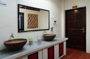 Baño con 2 lavabos en una encimera con espejo en Red Inn Court, en George Town