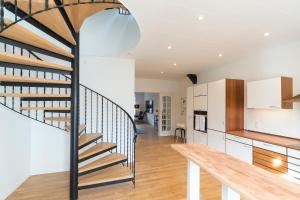 a staircase in a kitchen with white walls and wooden floors at City Center Penthouse in Sønderborg