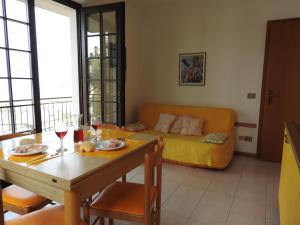 ein Wohnzimmer mit einem Tisch und einem gelben Sofa in der Unterkunft Piccolo Residence in Malcesine