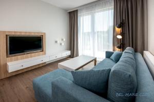 sala de estar con sofá azul y TV en BEL MARE Apartament C202 PARKING GRATIS en Międzyzdroje