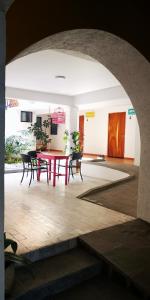 einen roten Tisch und Stühle in einem Zimmer mit Torbogen in der Unterkunft Santa Josefita B&B in Cholula de Rivadavia