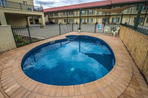 a large blue swimming pool in front of a building at Golden Guitar Motor Inn in Tamworth