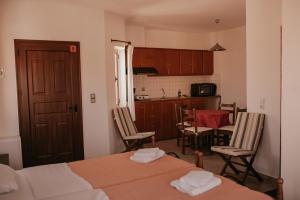 a room with a bed and a kitchen with a table and chairs at Flamingo Apartments in Palekastron