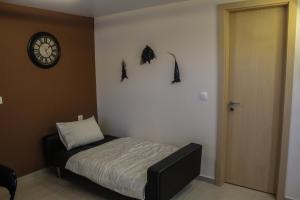 een slaapkamer met een bed en een klok aan de muur bij Sunshine penthouse in Pastida