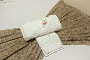 a pile of towels sitting on top of a bed at Hotel Royal Jaraguá in Jaraguá do Sul