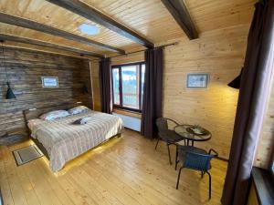 a bedroom with a bed and a table and chairs at AGORA Chalet in Slavske
