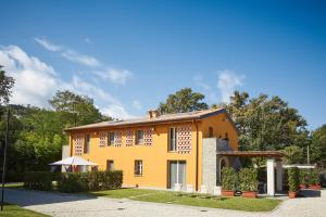 Casa da Giulio في كابانّوري: منزل أصفر كبير مع كراسي وأشجار