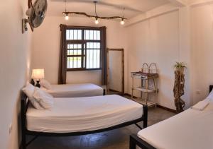 a bedroom with a white bed and white walls at Hostal Don Cenobio in Flores