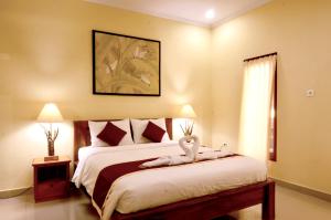 a bedroom with a bed with a stuffed animal on it at The Lod Villa in Ubud