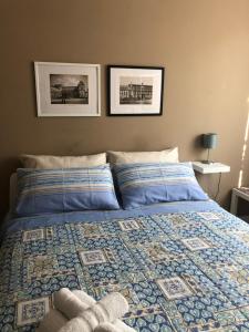 a bed with a blue comforter and two pillows at Jennys place in Palermo