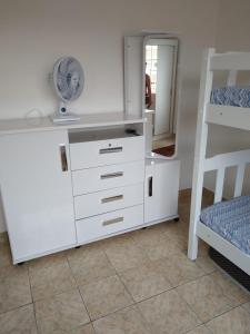 a white dresser with a fan and a bunk bed at Apartamento Espaçoso Renato Maia in Guarulhos