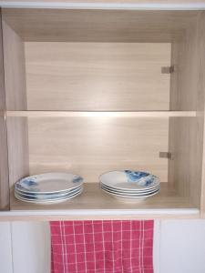 two plates are sitting in a wooden cabinet at Apartamento Espaçoso Renato Maia in Guarulhos